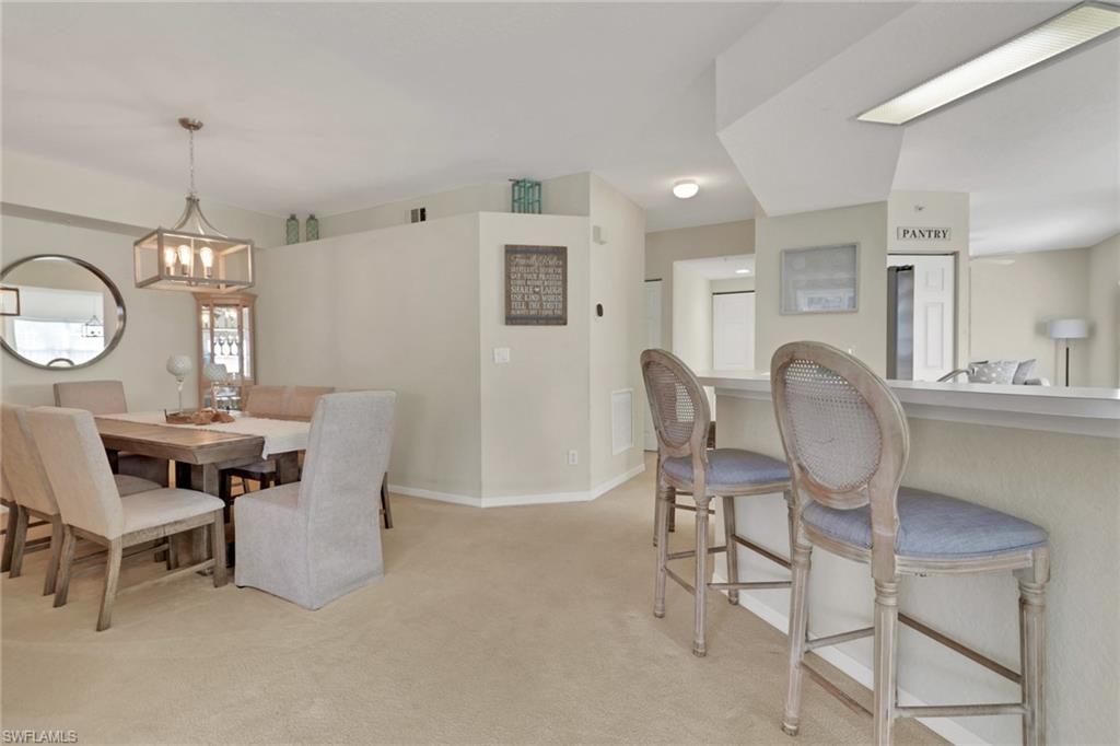 6923 Satinleaf Road North, Unit 101 Naples, FL 34109 - Photo 6 of 50 a view of a dining room with furniture and a chandelier