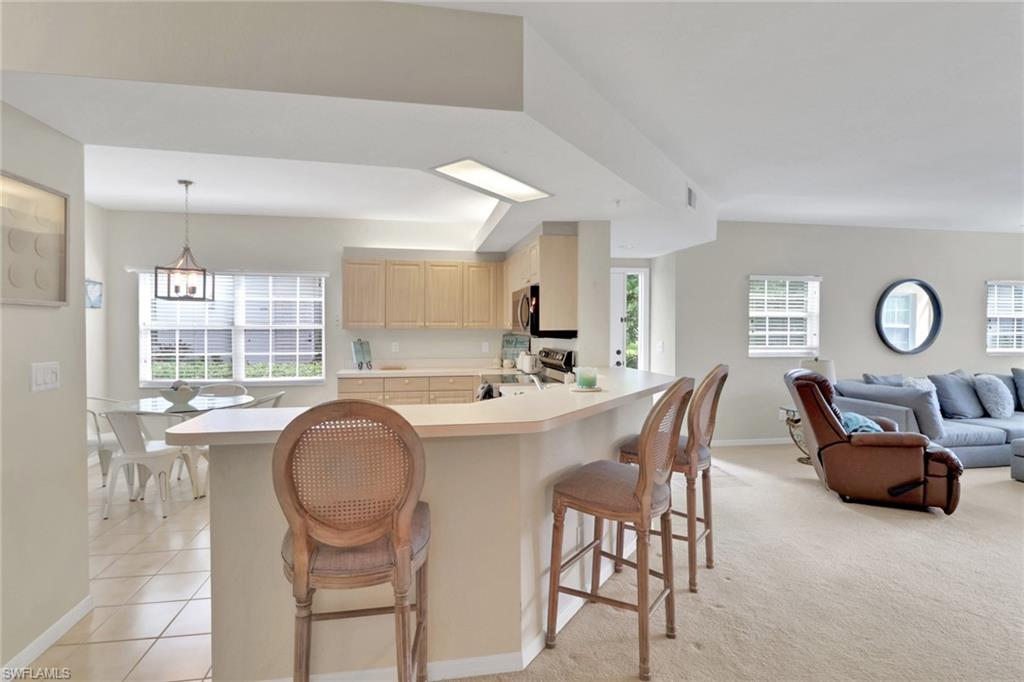 6923 Satinleaf Road North, Unit 101 Naples, FL 34109 - Photo 50 of 50 a living room with furniture a window and a table