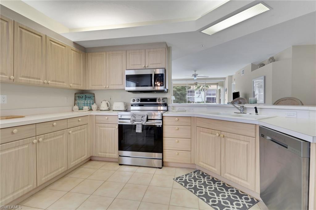 6923 Satinleaf Road North, Unit 101 Naples, FL 34109 - Photo 9 of 50 a kitchen with a sink stove and microwave