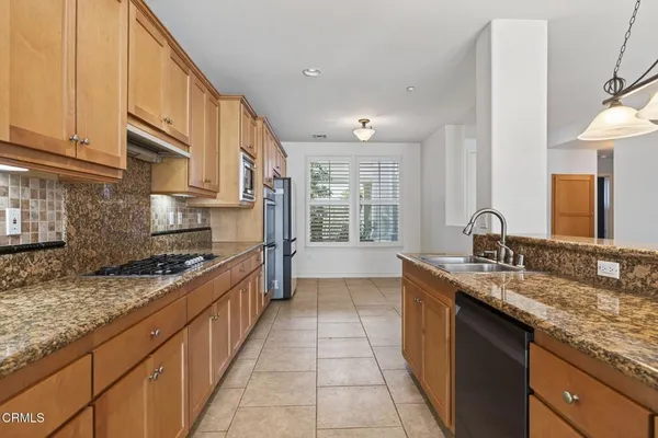 a kitchen with stainless steel appliances granite countertop a sink and cabinets