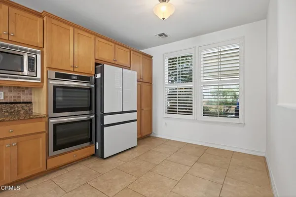a large kitchen with granite countertop a sink and a stove