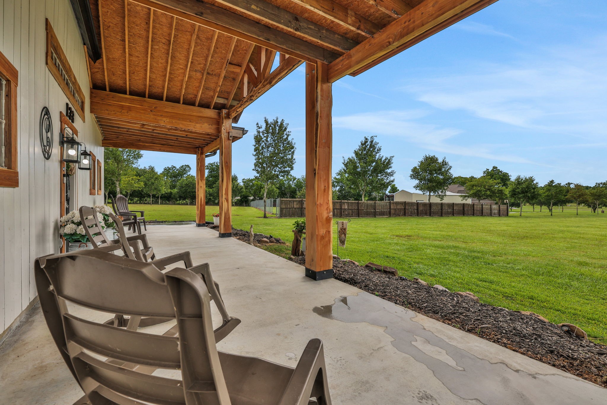 133 Timber Ridge Road Liberty, TX 77575 - Photo 3 of 29 a view of a patio with table and chairs potted plants with wooden floor and fence