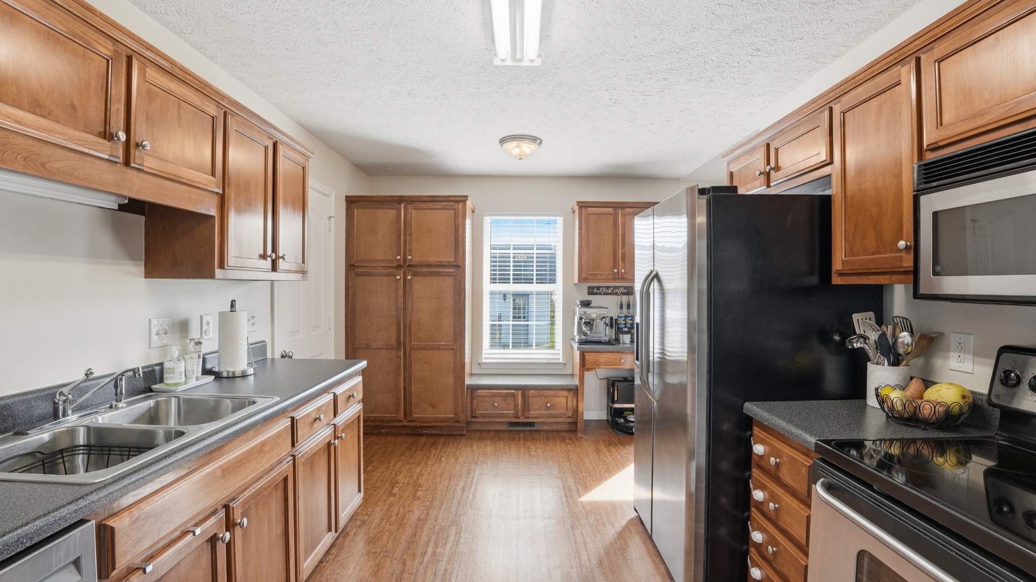 2877 Sixteenth Model Road Manchester, TN 37355 - Photo 21 of 38 a kitchen with stainless steel appliances granite countertop a refrigerator a sink dishwasher a stove and a dining table with wooden floor