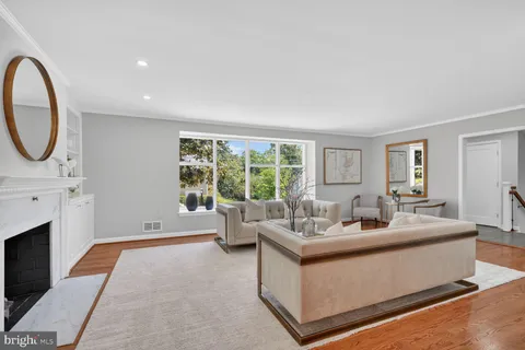 a living room with furniture a fireplace and a large window