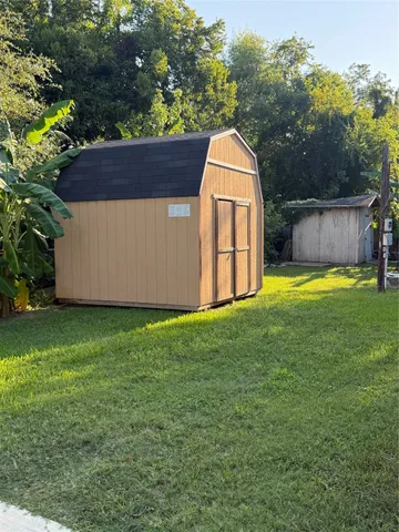 a view of a backyard with barn and wooden fence