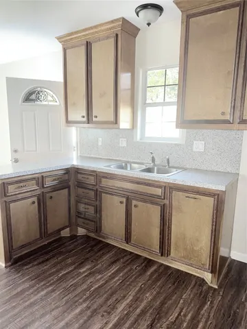 a kitchen with a sink window and cabinets