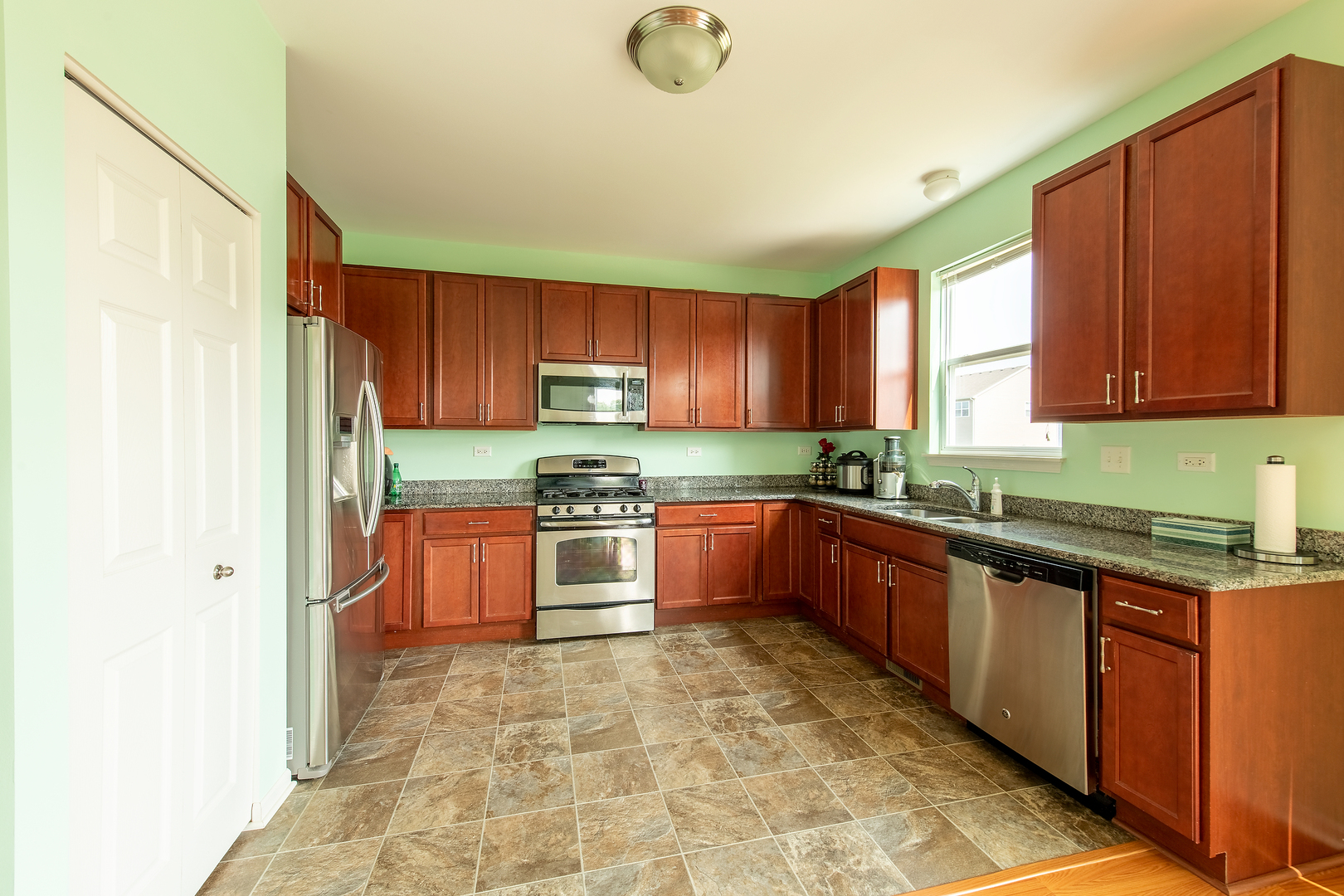 2692 Reedgrass Way Wauconda, IL 60084 - Photo 6 of 22 a large kitchen with granite countertop a stove a sink dishwasher and a refrigerator with wooden cabinets