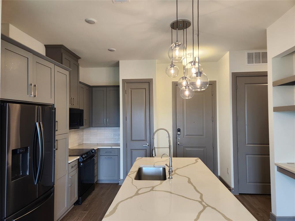 a kitchen with stainless steel appliances a chandelier and refrigerator