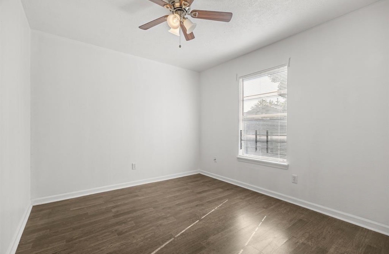 402 Paschall Street Houston, TX 77009 - Photo 7 of 11 an empty room with wooden floor and windows