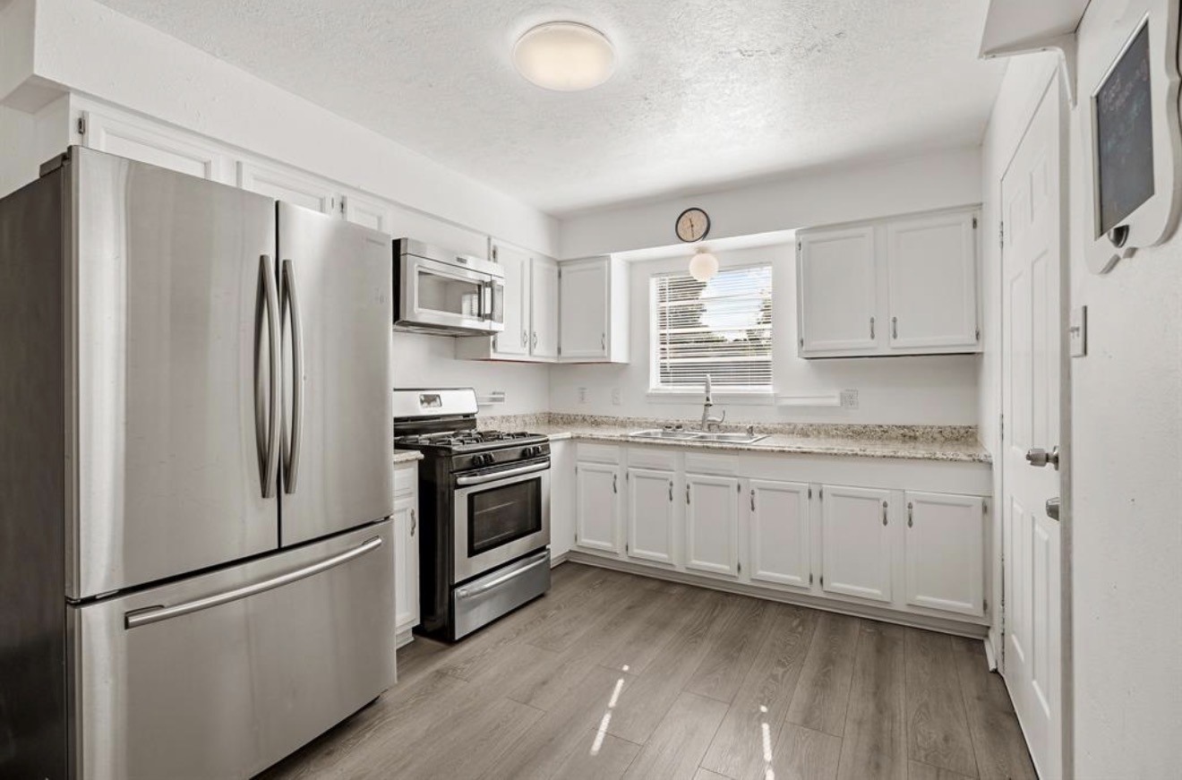 402 Paschall Street Houston, TX 77009 - Photo 9 of 11 a kitchen with granite countertop stainless steel appliances a refrigerator stove top oven and sink