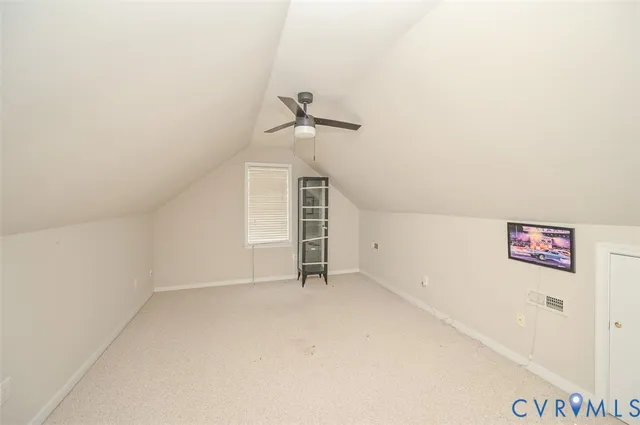 an empty room with a ceiling fan and carpet
