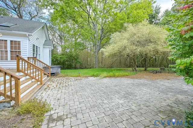 a view of a house with backyard and a tree
