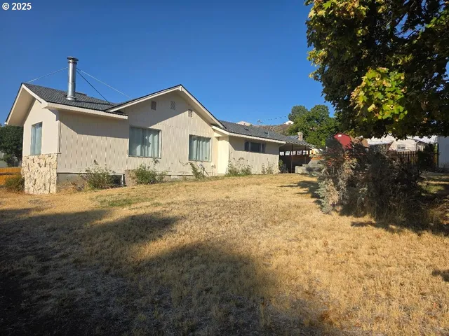 a front view of a house with a yard covered with snow