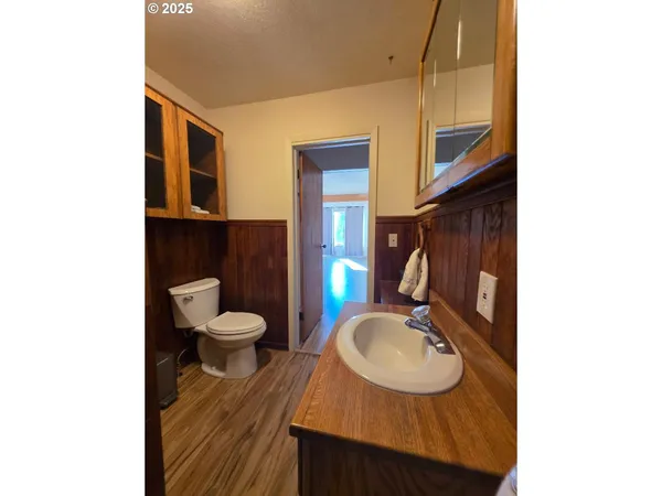 a bathroom with a granite countertop toilet sink and mirror