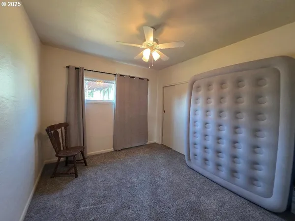 a view of a livingroom with a ceiling fan and a window
