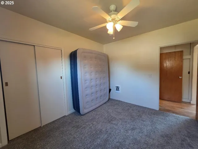 an empty room with chandelier fan