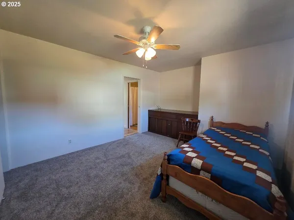 a bedroom with a bed and a chandelier fan