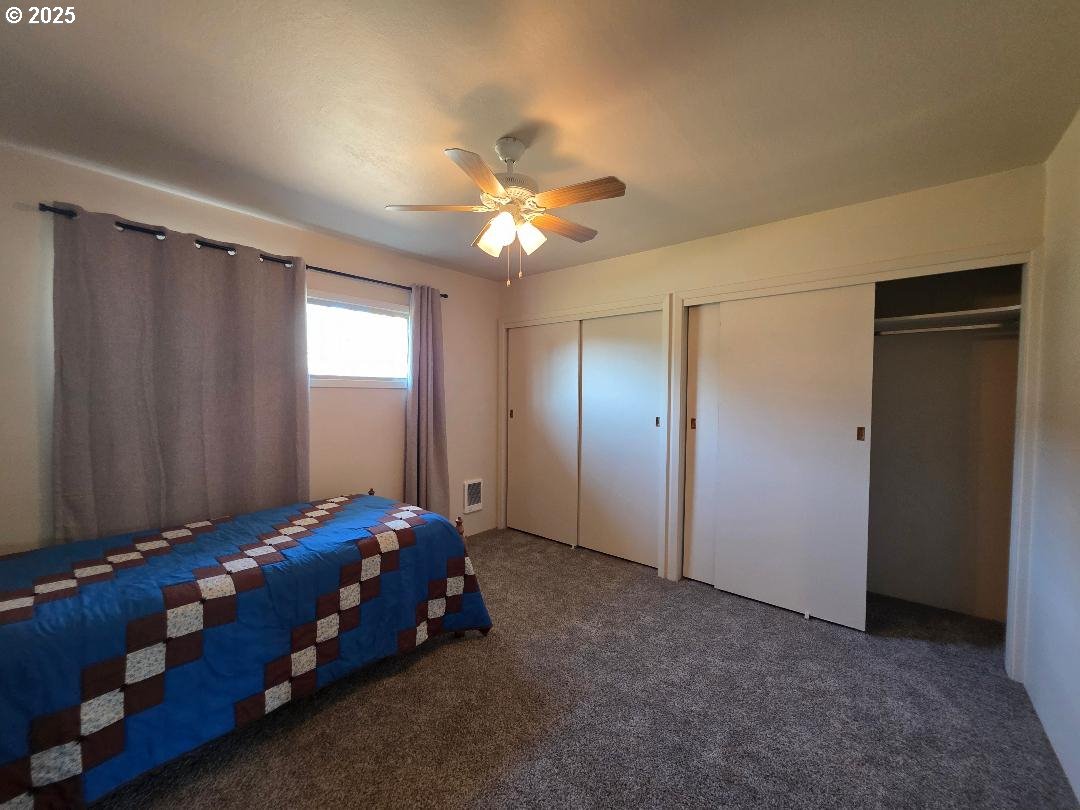 614 Staats Avenue Maupin, OR 97037 - Photo 22 of 39 a bedroom with a bed and a chandelier fan