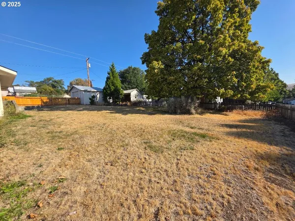 a view of a yard with trees in the background