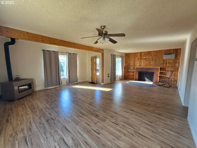 a view of a livingroom with wooden floor and a fireplace