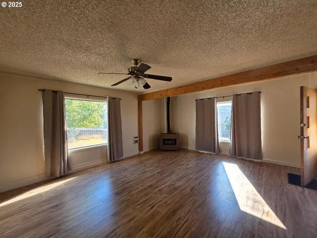 a view of a livingroom with wooden floor and a ceiling fan