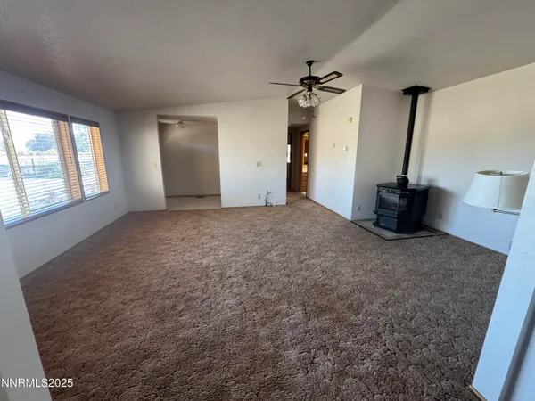 an empty room with windows and ceiling fan view