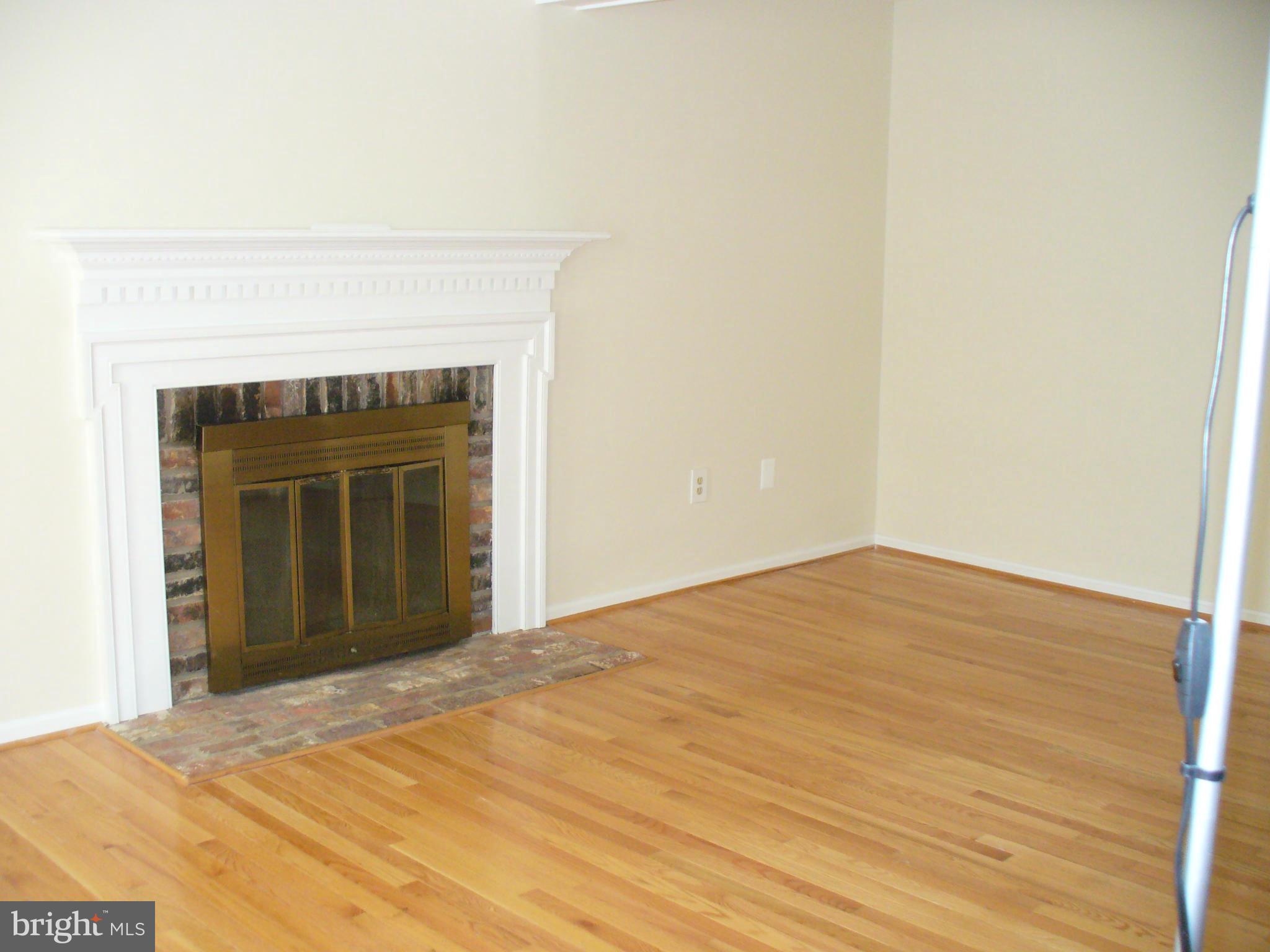 14331 Twig Road Silver Spring, MD 20905 - Photo 11 of 27 a view of an empty room with wooden floor and a fireplace
