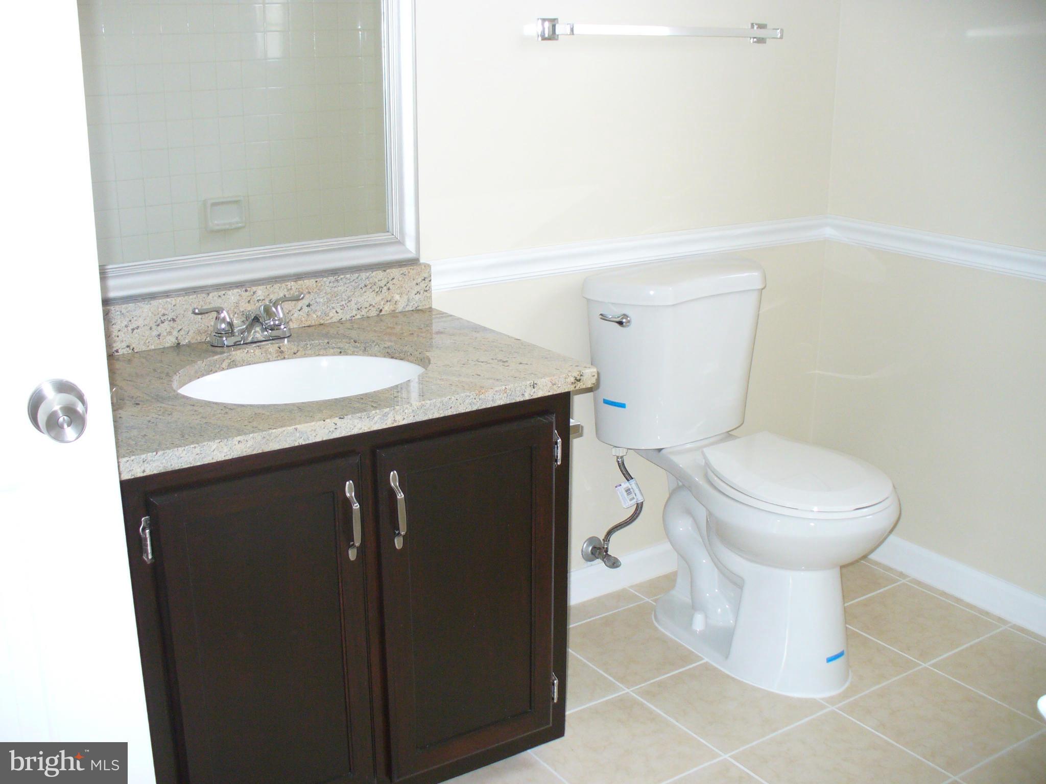 14331 Twig Road Silver Spring, MD 20905 - Photo 22 of 27 a bathroom with a granite countertop toilet sink and mirror