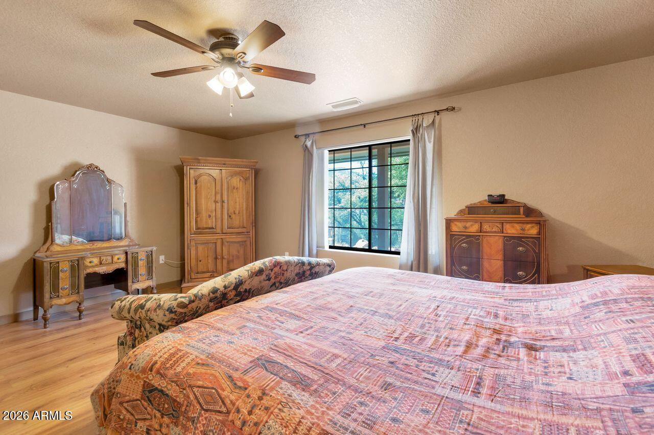 949 Rabbit Run Clarkdale, AZ 86324 - Photo 14 of 46 a bedroom with a large bed and a chandelier