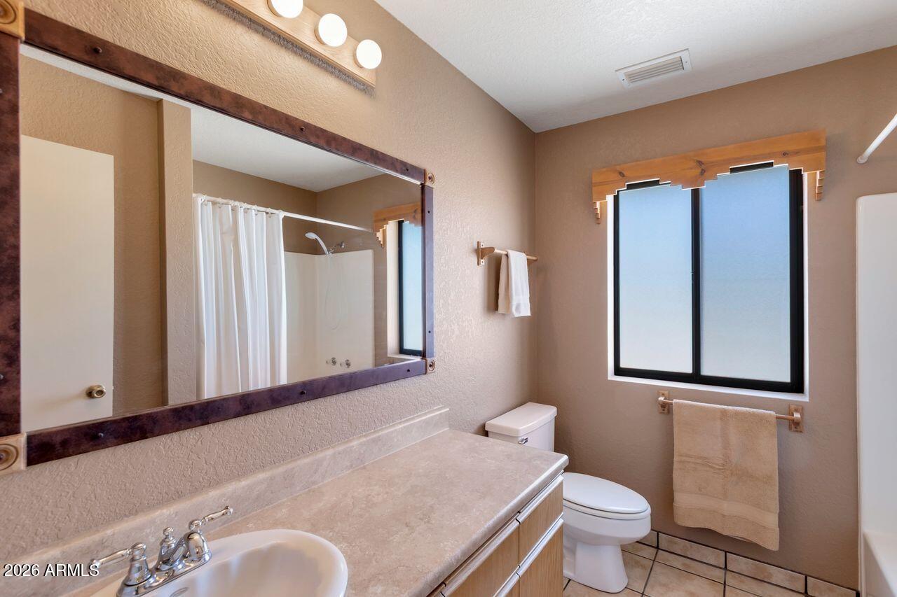 949 Rabbit Run Clarkdale, AZ 86324 - Photo 18 of 46 a bathroom with a granite countertop sink mirror vanity and toilet