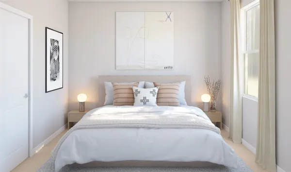 a large white bed in a room next to a window