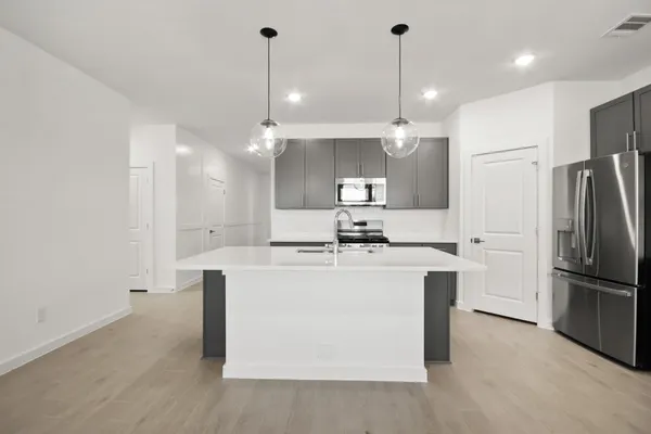 a kitchen with kitchen island a sink stainless steel appliances and cabinets