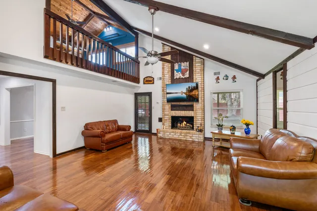 a living room with fireplace furniture and a wooden floor