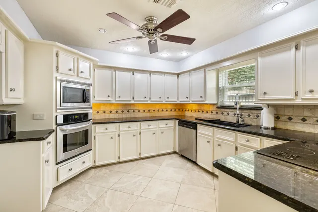 a kitchen with stainless steel appliances granite countertop a stove a sink and a refrigerator