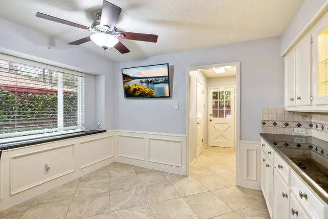 a kitchen with granite countertop white cabinets and white appliances