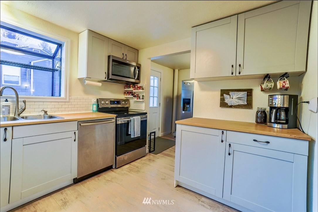 448 Windsor Way Northeast Renton, WA 98056 - Photo 6 of 20 a kitchen with cabinets stainless steel appliances and a sink