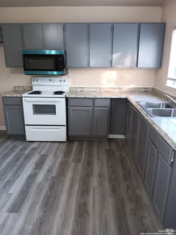 a kitchen with a stove a sink and a microwave