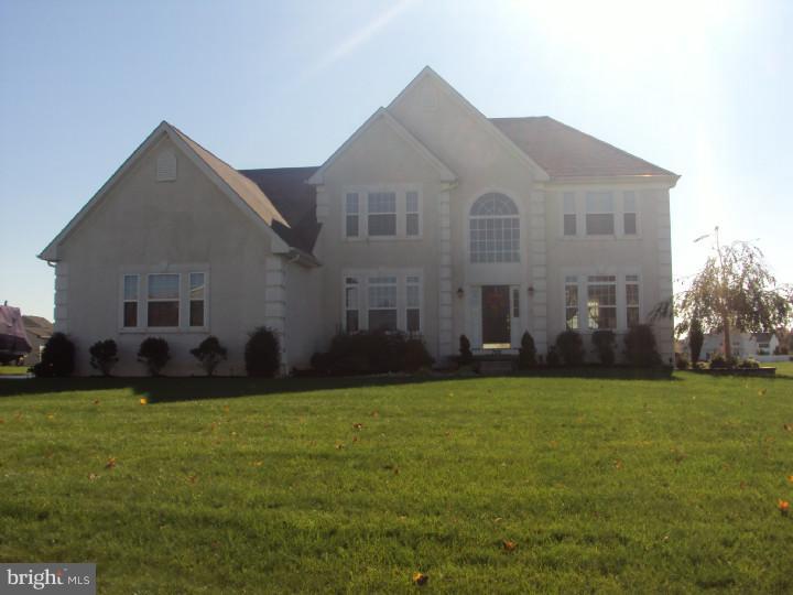 a large house with a big yard and more trees