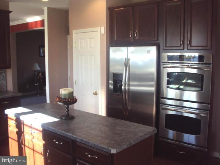 706 Farmhouse Road Mickleton, NJ 08056 - Photo 8 of 24 a kitchen with stainless steel appliances kitchen island granite countertop a refrigerator a stove and a sink with wooden floor