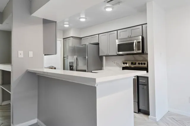 a kitchen with stainless steel appliances a refrigerator sink and microwave