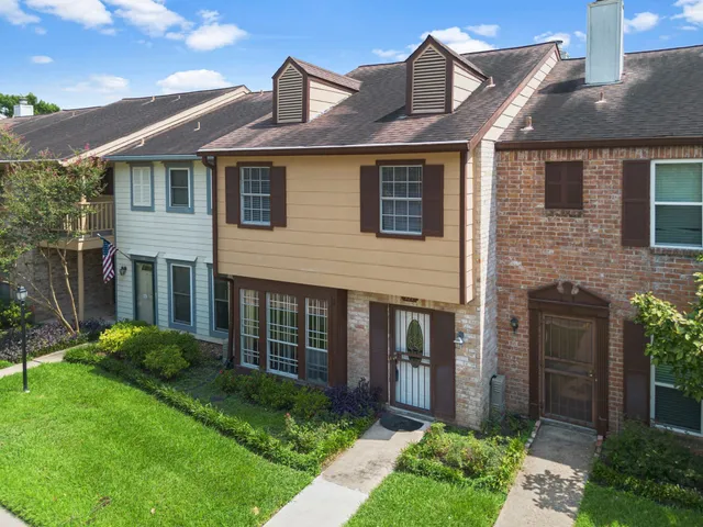 a front view of a house with a garden and plants