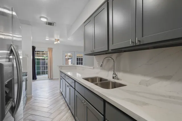 a kitchen with stainless steel appliances granite countertop a sink and a refrigerator