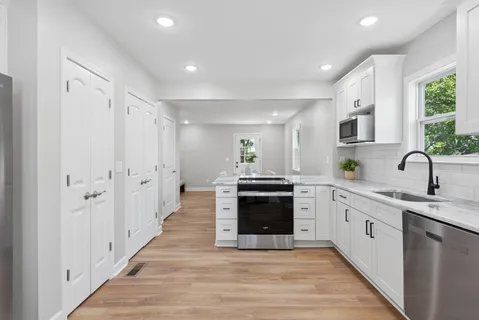 a large kitchen with stainless steel appliances granite countertop a stove and a sink