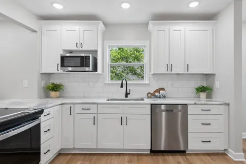 a kitchen with white cabinets stainless steel appliances and sink