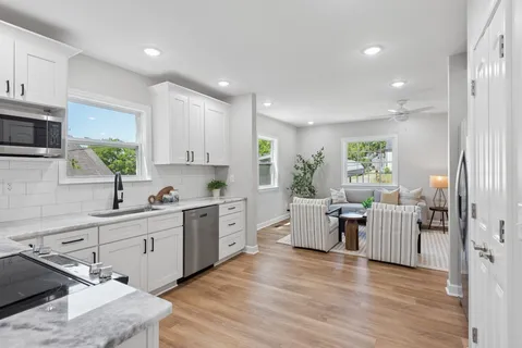 a kitchen with a sink cabinets and wooden floor