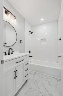 a bathroom with a tub sink and mirror