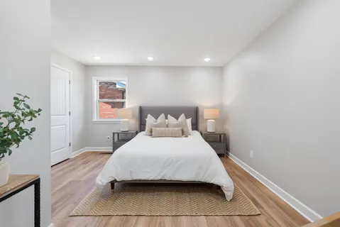a bedroom with a bed and a potted plant
