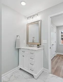 a bathroom with a granite countertop sink vanity and mirror