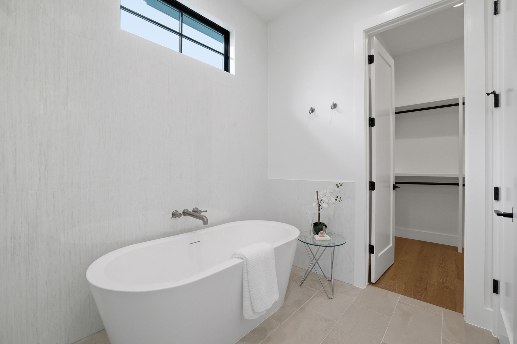 6611 Lexington Road Austin, TX 78757 - Photo 21 of 37 Freestanding soaking tub with wall-mounted faucet, complemented by large format floor tiling and a high transom window