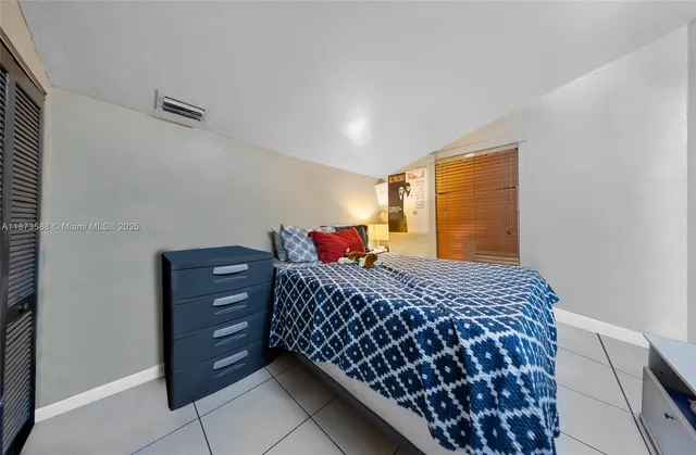 a bedroom with bed and a flat tv screen